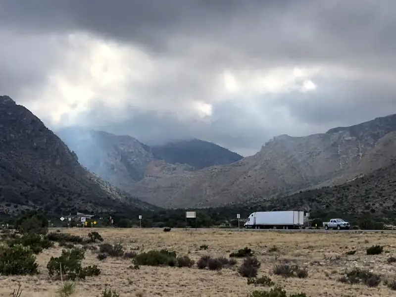 A highway passes in from of a desert mountain canyon