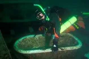 Diver poses with bathtub from the shipwreck Monarch.